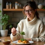 Femme souriante saupoudrant cilantro sur un plat de porc au curry