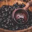 A close-up of a bucket full of cocoa beans and a wooden ladle in Cambridge.