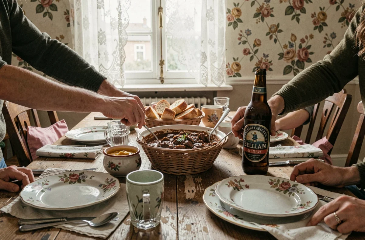 Table familiale du dimanche avec une carbonnade flamande servie en cocotte, accompagnée de tartines et de bière belge dans une maison du Nord